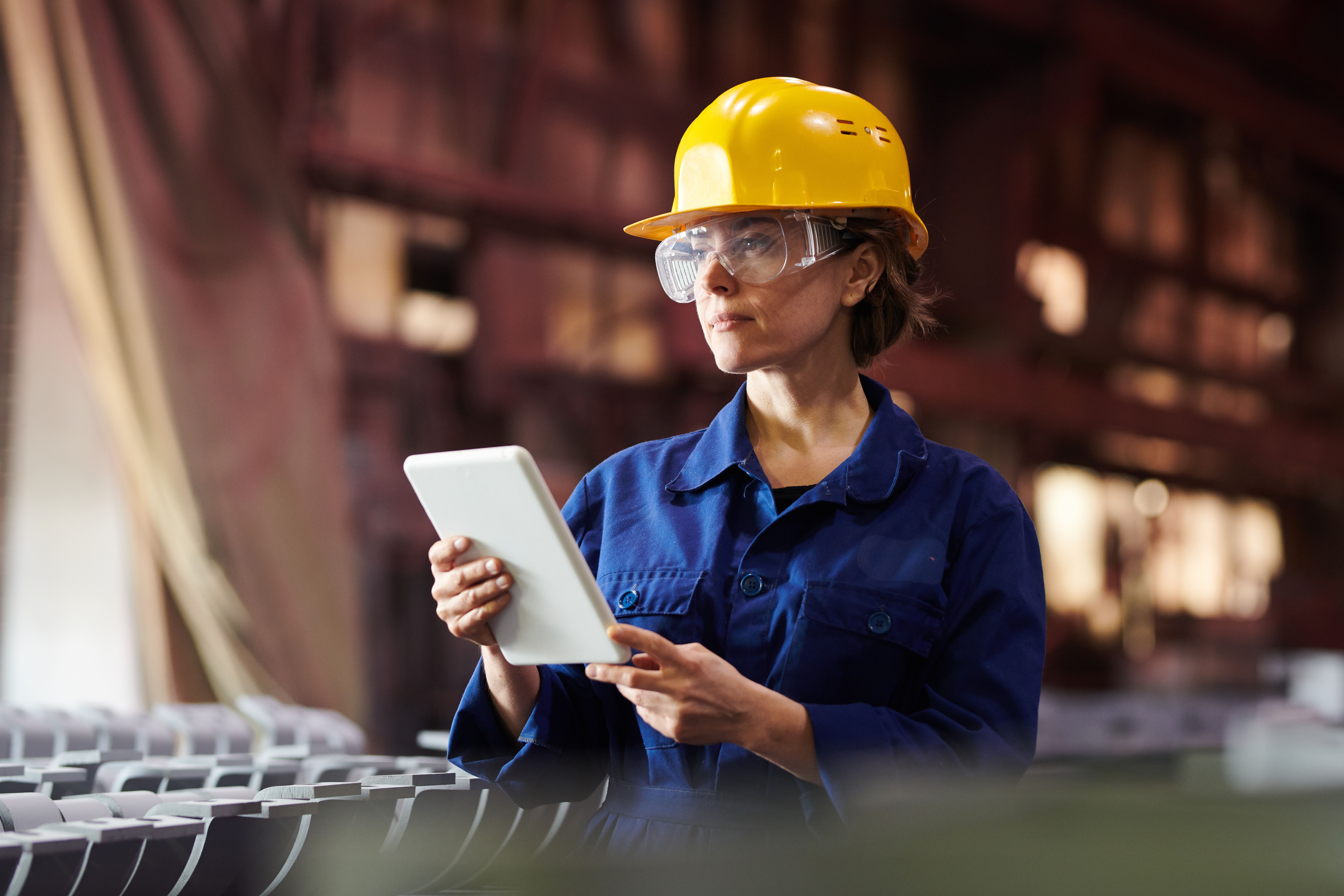 Woman wearing hard hat with tablet