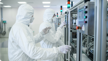 two semiconductor cleansuit workers configuring a machine