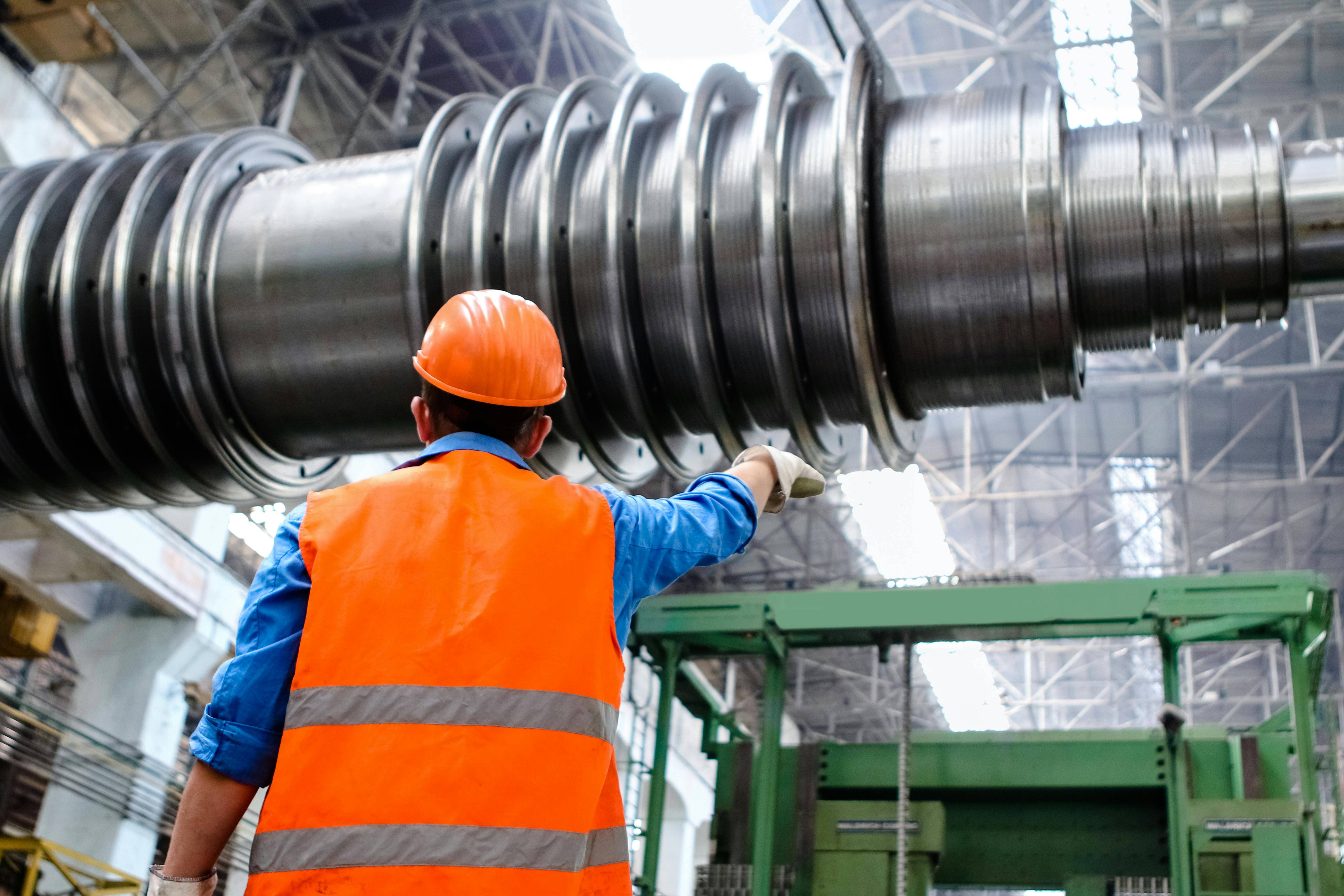 Worker inspecting large industrial machinery